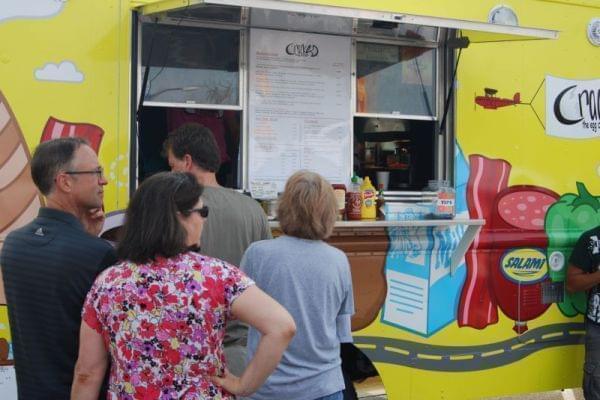 People waiting in line to order food from a food truck.