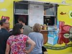People waiting in line to order food from a food truck.