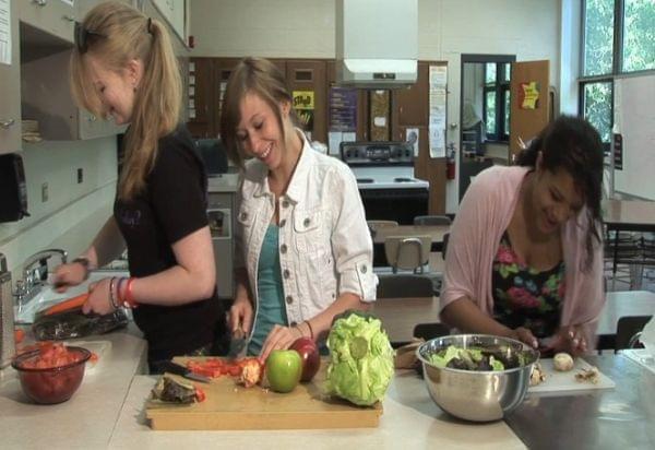 Urbana High School students Kaitlyn Breitenfeldt, Miranda Bullok, and Tessla Varvel make a salad in the school's teaching kitchen.