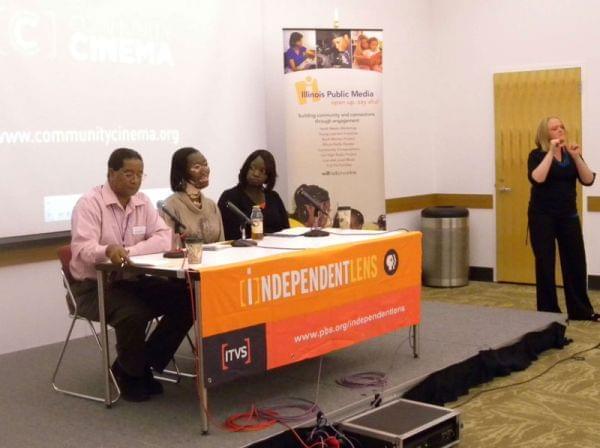 Members of the panel at the Community Cinema screening at a table in the Champaign Public Library
