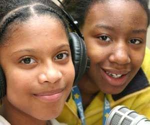 two students sitting in front of radio microphone