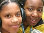 two students sitting in front of radio microphone