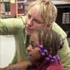 Kimberlie Kranich helping student edit video at the computer.