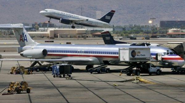 US Airways jet takes off as an American Airlines jet is prepped for takeoff