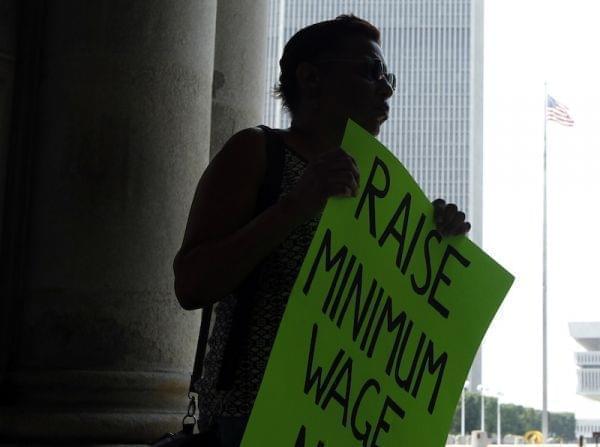 Wendy Brown holds sign before an Occupy Albany rally pushing for a raise in New York's minimum wage