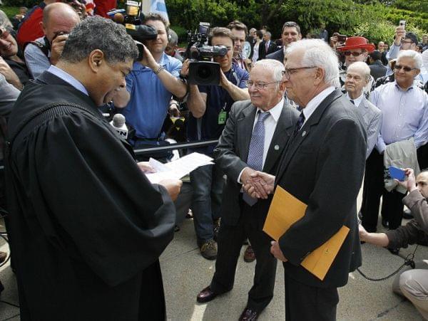 Cook County Chief Judge Tim Evans, left, presides over the civil union of James Darby, center, and Patrick Bova during ceremonies in Chicago's Millennium Park Thursday, June 2, 2011 in Chicago.