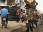 People walk down a market street in Eastleigh