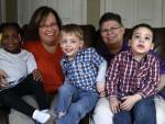 April DeBoer (second from left) sits with her adopted daughter Ryanne, 3, and Jayne Rowse and her adopted sons Jacob, 3, and Nolan, 4, at their home in Hazel Park, Mich., on Tuesday.