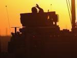 A soldier in the last American military convoy to depart Iraq, from the 3rd Brigade, 1st Cavalry Division, waves after crossing over the border into Kuwait on Dec. 18, 2011.