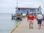 Two men walking on a pier toward a restaurant