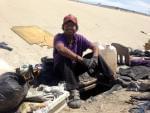 immigrant deported from Riverside, Calif. sits next the hole he lives in beneath Tijuana's fetid river canal.
