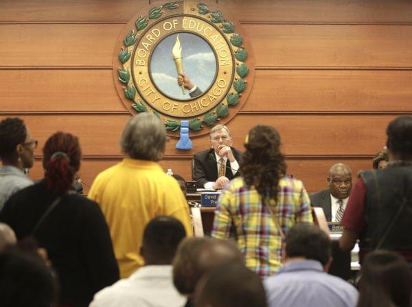 Chicago Board of Education President David Vitale, center, listens to opponents of proposed school closures at a packed board meeting Wednesday, May 22, 2013, in Chicago.