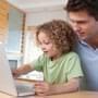 Girl and dad play reading games on laptop computer