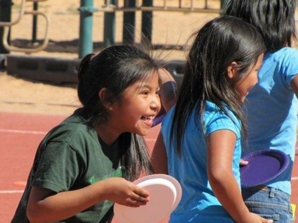An elementary school student enjoys Field Day on a playground.