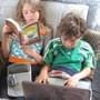 Girl reading and boy using laptop
