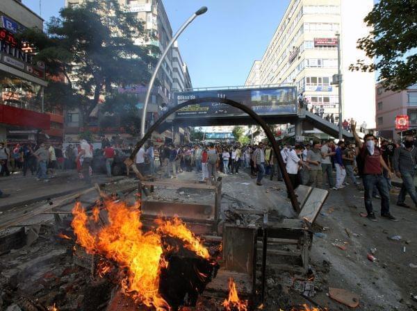Turkish youths shout slogan " Tayyip, resign! " as they clash with security forces in Ankara, Turkey, Saturday, June 1, 2013.