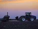 A central Illinois farmer plants corn seed into the evening in Farmingdale, Ill.