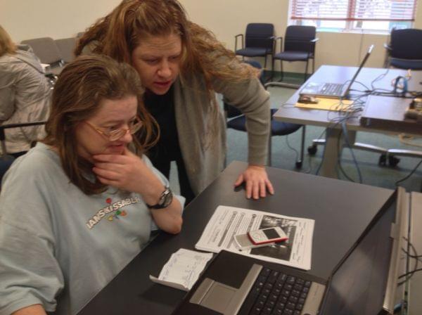 Charlene Aumiller (left) gets help with the health care marketplace from Shannon Killian (right) of the Champaign-Urbana Public Health District on Oct. 1, 2013.