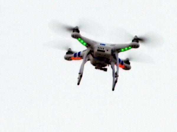 A remote-controlled quadcopter hovers over a Bloomington, Ill., parking lot, where Colby offered test flights of new unmanned vehicle models.