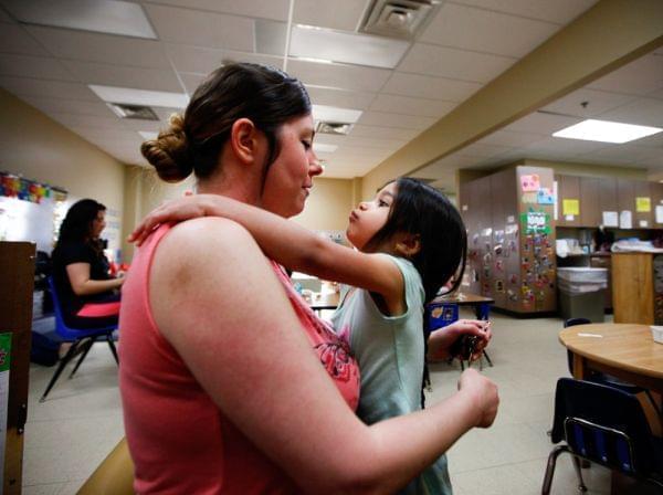 Tiffany Contreras kisses her daughter Kyndall, 4, goodbye at Disney Elementary in Tulsa, Okla. As part of a pilot program that aims to educate both children and families, Contreras takes classes at Tulsa Community College for free.