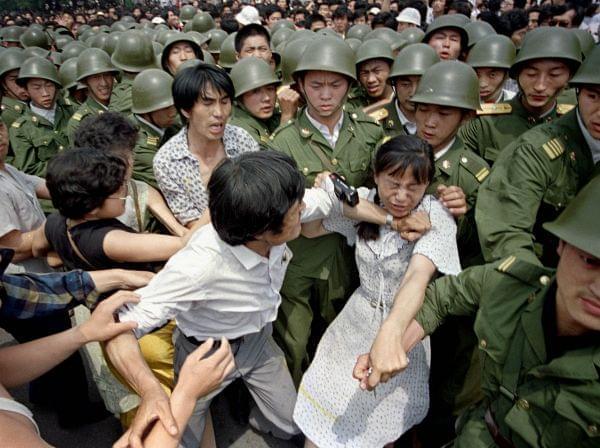 A young woman is caught between civilians and Chinese soldiers, who were trying to remove her from an assembly near the Great Hall of the People in Beijing, June 3, 1989. Pro-democracy protesters had been occupying Tiananmen Square for weeks.