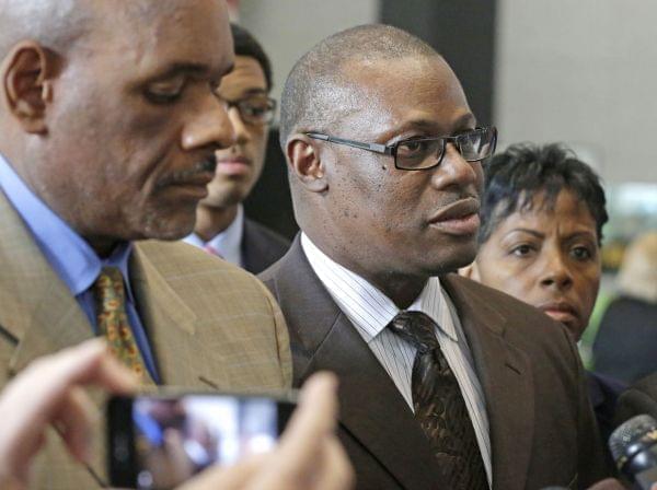 Illinois state Rep. Derrick Smith, center, speaks to reporters at the federal building Tuesday, June 10, 2014, in Chicago after a jury convicted him of bribery for taking $7,000 from a purported day care operator seeking a state grant. Listening at l