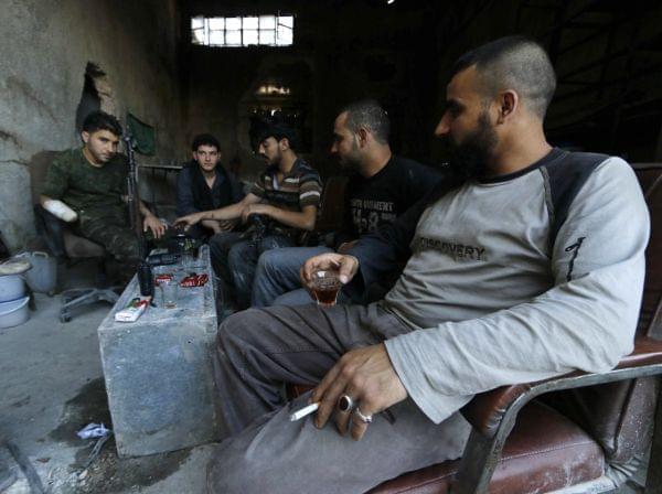 Rebel fighters drink tea on the front line of Ramouseh, near the Aleppo Artillery School. President Obama has requested $500 million to arm and train "moderate" Syrian rebel groups.