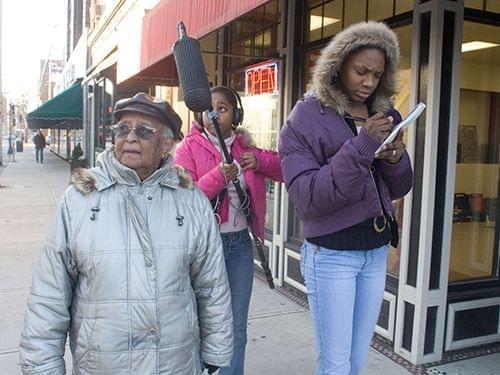Erma Bridgewater walks through downtown Champaign with Youth Media Workshop students Isis Griffin and Amaris Bailey