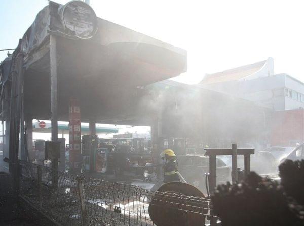 Israeli firefighters extinguish vehicles at a gas station hit by rocket fire.