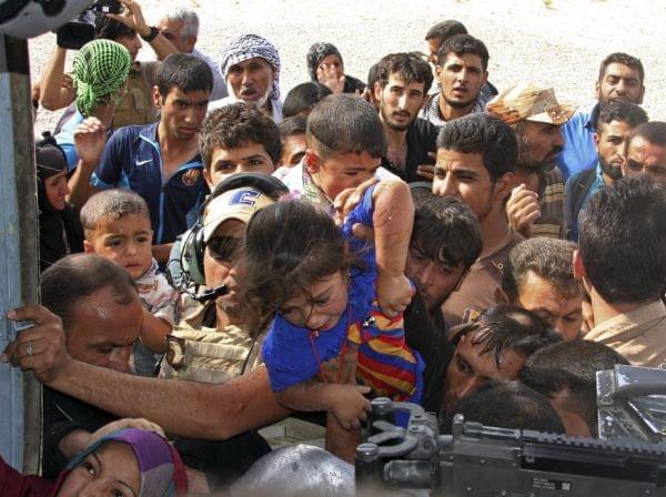 People try to board an Iraqi helicopter bringing supplies in Amerli.