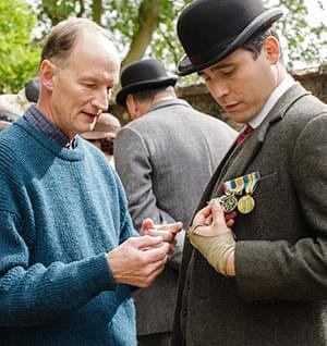 Alastair Bruce describes Thomas' medals to actor Rob James-Collier.