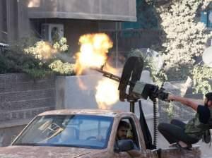 A member of the Free Syrian Army opens fire with a machine gun during clashes with Syrian army forces in Aleppo on Sept. 27, 2012. 