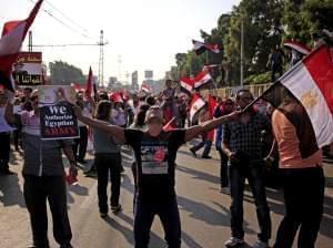 Opponents of Egypt's Islamist President Mohammed Morsi wave national flags during a protest outside the presidential palace, in Cairo, Egypt, Wednesday, July 3, 2013.