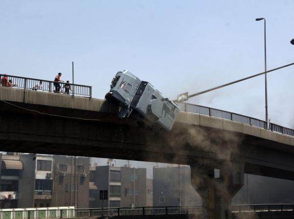 A police vehicle is pushed off of the 6th of October bridge by protesters close to the largest sit-in by supporters of ousted Islamist President Mohammed Morsi in the eastern Nasr City district of Cairo, Egypt, Wednesday, Aug. 14, 2013.
