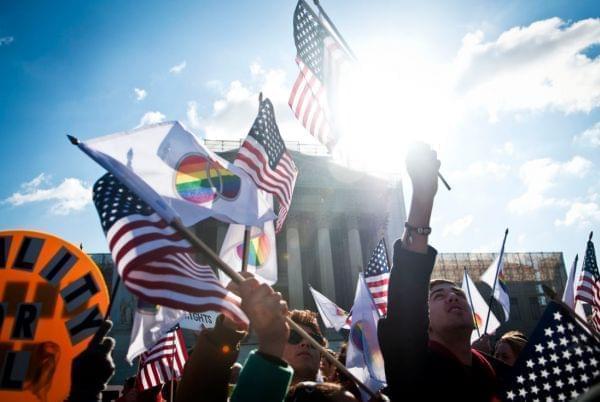 Supporters wave American and gay rights flags outside the Supreme Court during the Defense of Marriage Act case hearings on Wednesday in Washington, D.C.