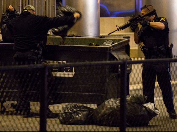 Police officers search an area of the Massachuettes Institute of Technology, where one of the suspects was shot.