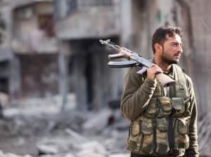 A Free Syrian Army fighter holds his rifle as he stands on a damaged street in Aleppo on Nov. 29, 2012.