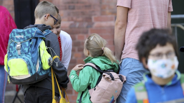 Students are brought to school by their parents in Rostock, Germany Monday, Aug. 3, 2020 as Mecklenburg-Western Pomerania is the first federal state to resume regular school operations throughout the state. About 150,000 students are expected to attend their schools.