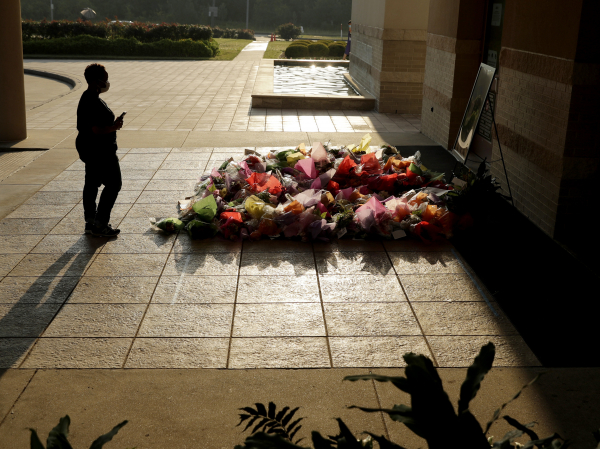A woman stops to photograph a memorial for George Floyd at The Fountain of Praise church on Tuesday in Houston.