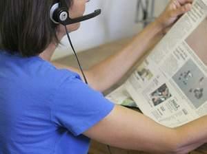 Illinois Radio Reader volunteer reading a newspaper