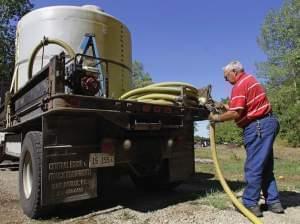 Carl Marion of Athens, Ill., pumps water from his 2,000 gallon water tank