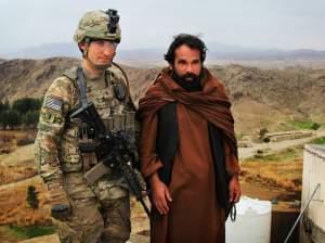 Marine Lt. Phillip Baki visits with an Afghan police officer, Abdul Karim