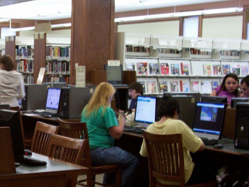 people working at computers in a library
