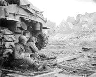 Soldier sitting by a tank