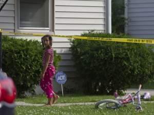 a young girl watches as police respond to a double homicide in Michigan.