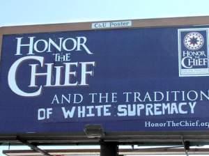Defaced billboard saying Honor the Chief with graffiti changing the meaning