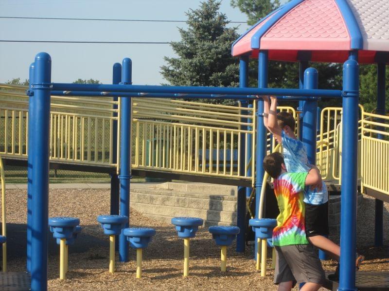 Alex Whiteman helps his brother Rylan, who has cerebral palsy, off the monkey bars at the Playground for Everyone in Danville, Ill.
