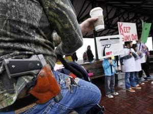 A Starbucks customer — gun on his hip and drink in his hand — watches a rally by gun control advocates, in Seattle in 2010.