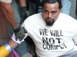 protester wearing T-shirt with words "We will not comply."