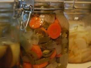 A jar of pickled carrots on a kitchen shelf